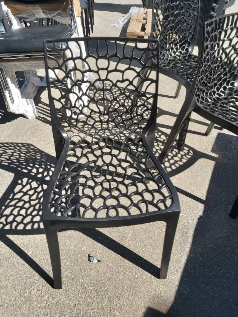 Cadeira de plástico com design vazado em formato de teia de aranha