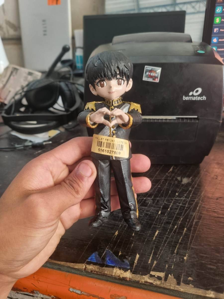 Figura colecionável de personagem masculino em uniforme preto com detalhes dourados