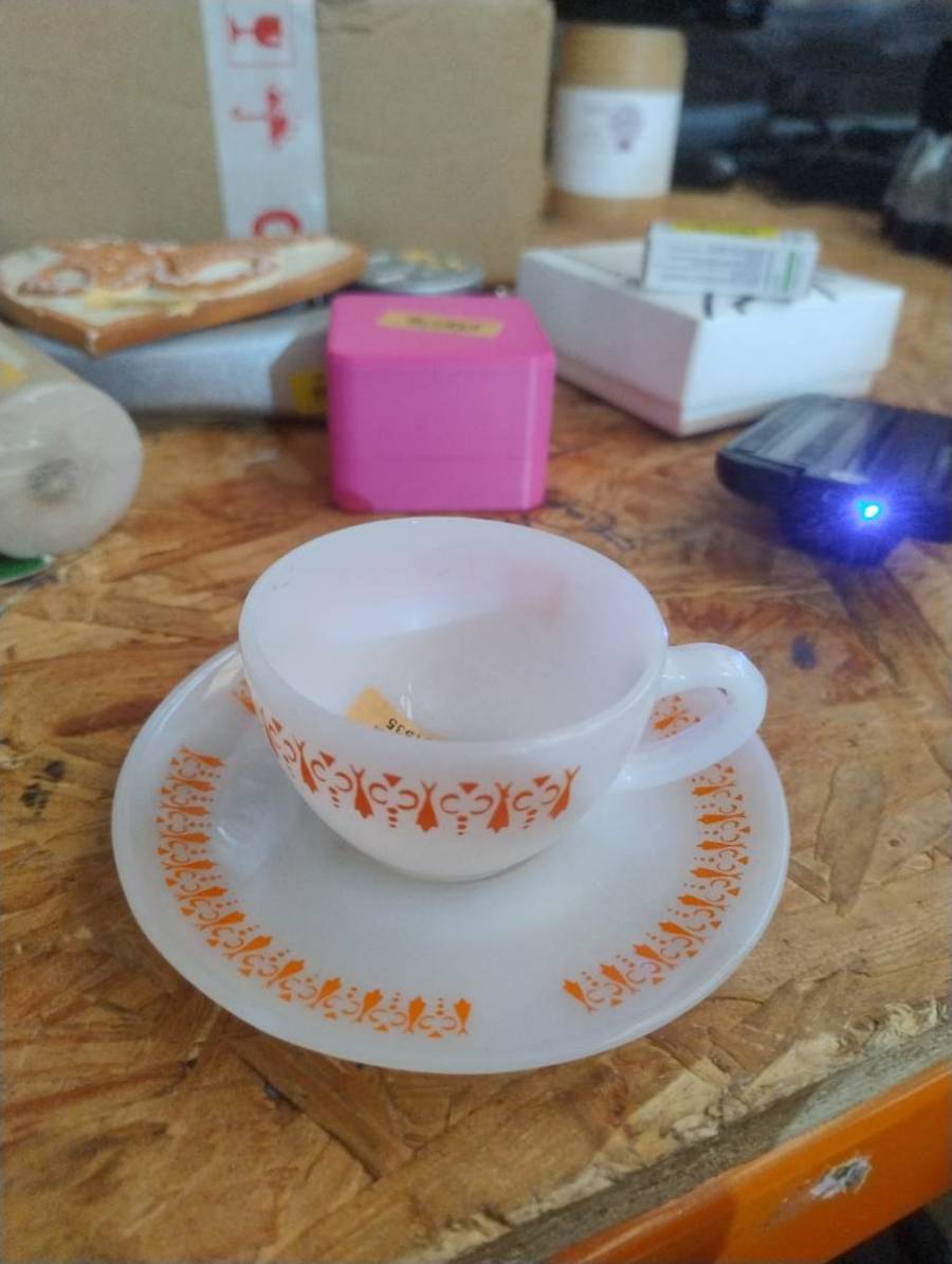 Conjunto de xícara e pires de porcelana com estampa laranja