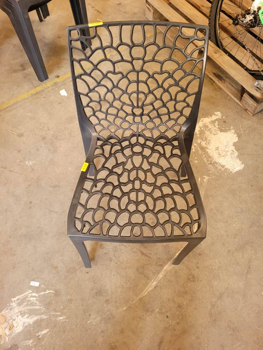 Cadeira plástica com design vazado em formato de teia de aranha