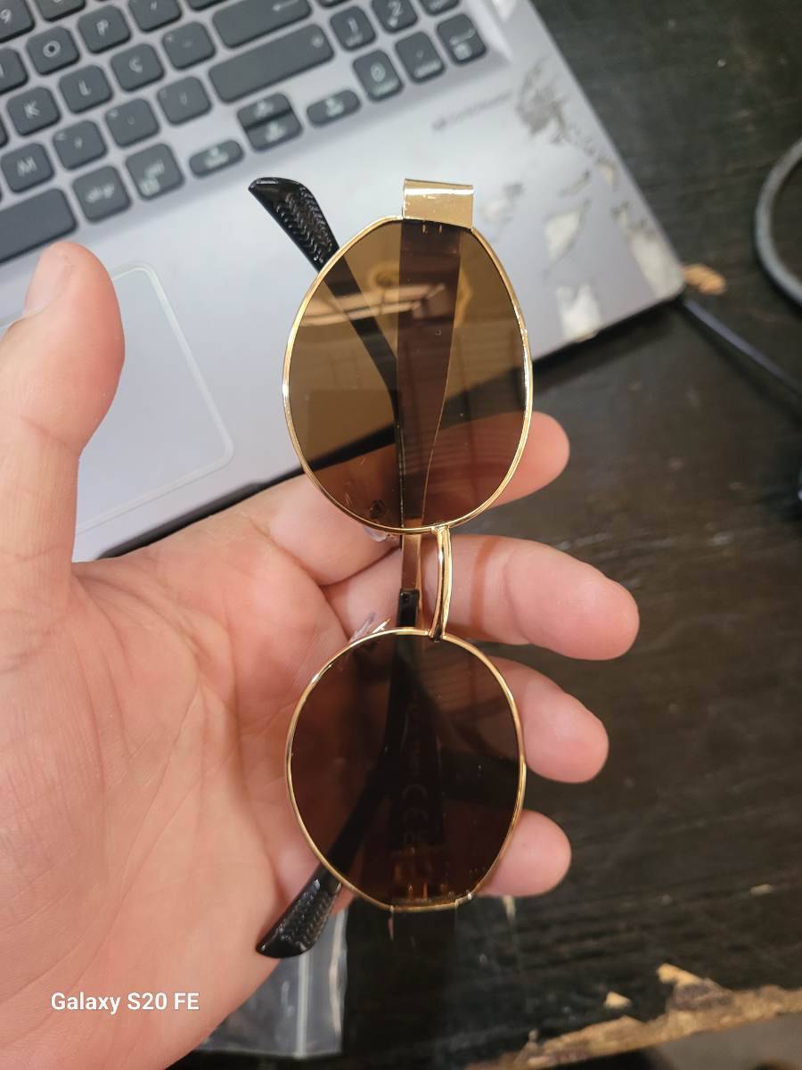 Óculos de sol com armação dourada e lentes escuras