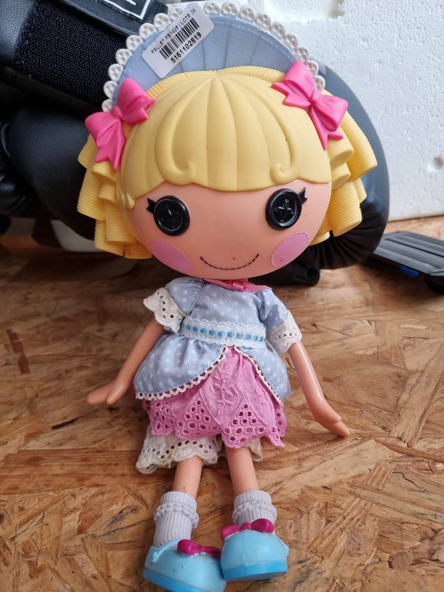 Boneca de brinquedo com vestido azul e rosa, cabelo loiro e laços rosa