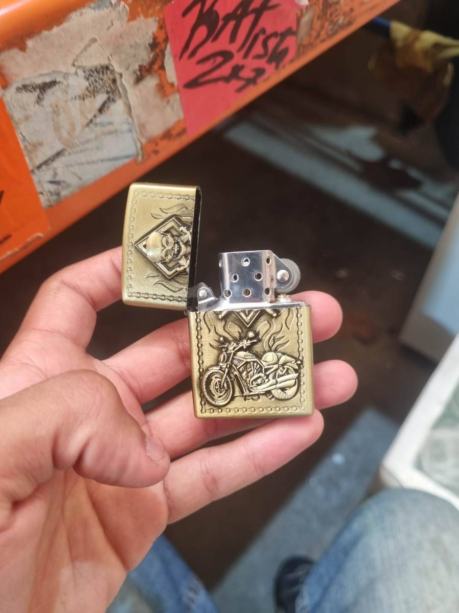 Isqueiro metálico com relevo de motocicleta e caveira