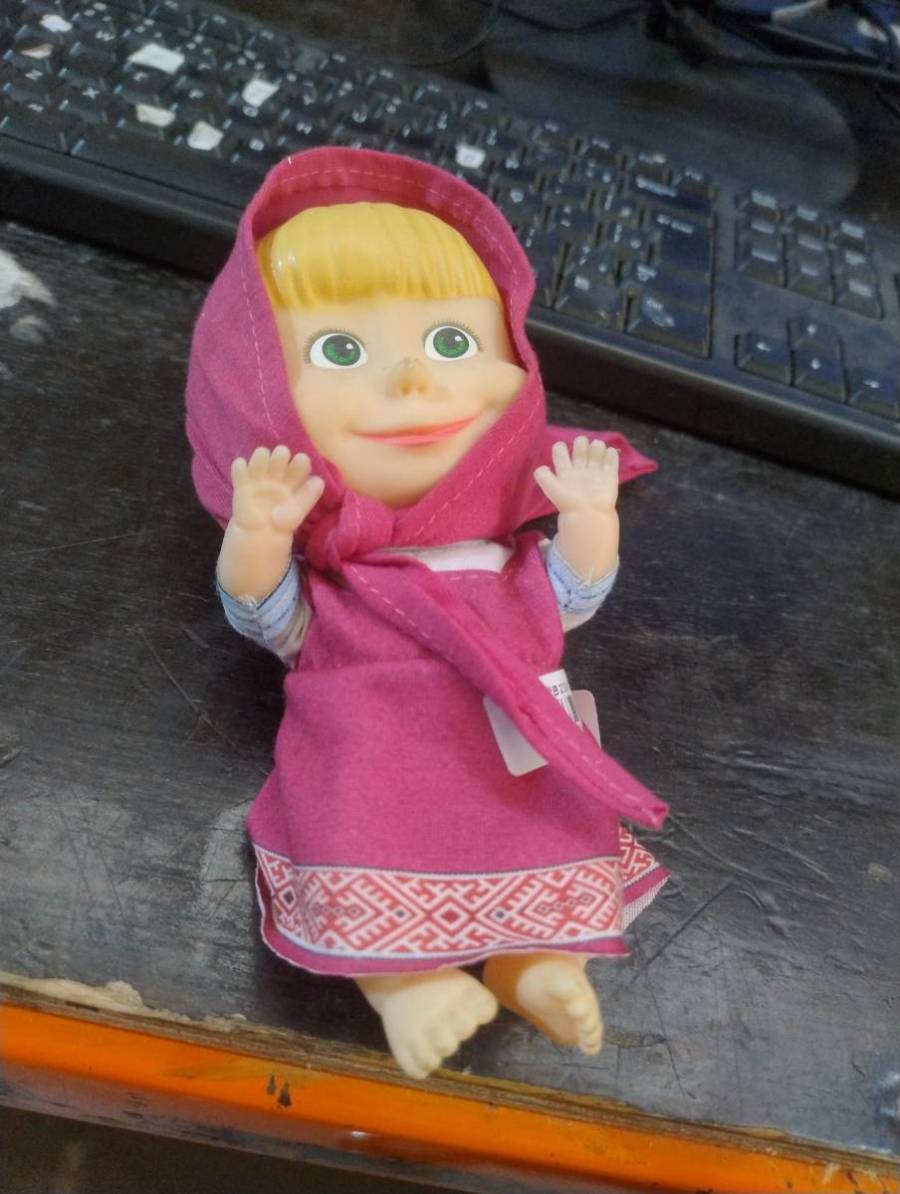 Boneca vestida com roupa rosa e lenço na cabeça